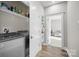 Bright laundry room with washer/dryer, shelving, and wood flooring at 511 E Main St, Rock Hill, SC 29730