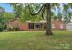 Brick ranch home with a covered porch and landscaped yard at 102 Goodman Ne Cir, Concord, NC 28025