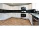 Modern kitchen with white cabinets, granite counters, and stainless steel appliances at 406 Harris Ln, Monroe, NC 28112