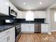 Modern kitchen with white cabinets, granite counters, and stainless steel appliances at 406 Harris Ln, Monroe, NC 28112