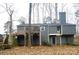 View of the back of the home with an elevated wood deck, chimney, exterior door and wood staircase at 958 Sherwood Cir, Lancaster, SC 29720