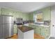Eat-in kitchen with stainless steel appliances, light green cabinetry, and view to the backyard at 958 Sherwood Cir, Lancaster, SC 29720