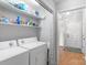 Laundry room features side-by-side washer and dryer, shelving, and wood-look floors at 958 Sherwood Cir, Lancaster, SC 29720