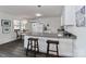 White kitchen with L-shaped counter, stainless steel sink, and breakfast bar at 110 Fern Haven Ln, Mooresville, NC 28117