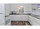 White kitchen with L-shaped counter, stainless steel sink, and breakfast bar at 110 Fern Haven Ln, Mooresville, NC 28117