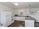 White kitchen with L-shaped counter, stainless steel sink, and breakfast bar at 110 Fern Haven Ln, Mooresville, NC 28117