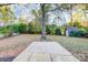 Expansive backyard featuring a concrete pad, storage shed, and mature trees offering privacy and shade at 13446 Idlefield Ln, Matthews, NC 28105