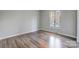 Empty bedroom with hardwood floors and a window letting in natural light at 13446 Idlefield Ln, Matthews, NC 28105