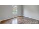 Empty bedroom with hardwood floors and a window letting in natural light at 13446 Idlefield Ln, Matthews, NC 28105