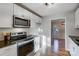 Well-lit kitchen featuring white cabinets, stainless steel appliances, and granite countertops at 13446 Idlefield Ln, Matthews, NC 28105