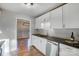 Bright kitchen showcasing white cabinetry, stainless steel dishwasher, and dark countertops at 13446 Idlefield Ln, Matthews, NC 28105