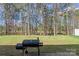 Spacious backyard featuring a charcoal grill, grass lawn and natural views at 3015 Hendricks Chapel Ln, Charlotte, NC 28216