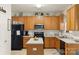 Kitchen with oak cabinetry, black appliances, and a functional island, perfect for meal preparation at 3015 Hendricks Chapel Ln, Charlotte, NC 28216