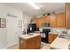 Kitchen with oak cabinetry, black appliances, and island, ideal for culinary enthusiasts at 3015 Hendricks Chapel Ln, Charlotte, NC 28216