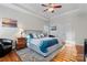 Bright main bedroom featuring a tray ceiling, hardwood floors, and a comfortable bed at 428 Vintage Hill Ln, Huntersville, NC 28078