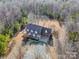 Aerial view of brick home with dormer windows and ample parking surrounded by lush woods at 6610 Rolling Ridge Dr, Waxhaw, NC 28173