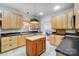 Well-lit kitchen with custom wood cabinets, dark countertops, and a central island at 6610 Rolling Ridge Dr, Waxhaw, NC 28173