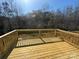Large outdoor deck with wood flooring and railing overlooking a lush tree-lined backyard at 202 Fostoria Pl # 78B, Albemarle, NC 28001