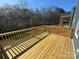 Large outdoor deck with wood flooring and railing overlooking a lush tree-lined backyard at 202 Fostoria Pl # 78B, Albemarle, NC 28001