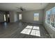 Bright, open-concept living room featuring vinyl floors, large windows, and modern ceiling fan at 202 Fostoria Pl # 78B, Albemarle, NC 28001