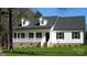 Charming white home with black shutters, dormers, and welcoming front porch on a bright, sunny day at 2270 Charlotte Hwy, York, SC 29745