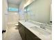 Well-lit bathroom with double sinks, white marble countertops, dark wood cabinets, and shower with a tub at 3850 Willow Grove Ln # 24, Concord, NC 28025