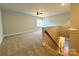Bright bonus room featuring neutral carpet, a ceiling fan, and staircase to downstairs living areas at 3850 Willow Grove Ln # 24, Concord, NC 28025