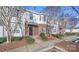 Street view of well-maintained townhomes featuring a brick facade and professionally landscaped yard at 4143 Kenton Glenn Nw Ct, Concord, NC 28027