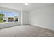 Bright bedroom with a large window offering neighborhood views and neutral carpet at 5527 Stafford Rd # 34, Charlotte, NC 28215