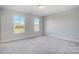 A bedroom with neutral carpet and two windows overlooking a neighborhood at 5527 Stafford Rd # 34, Charlotte, NC 28215