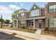 Charming brick townhome featuring gray shutters, craftsman columns, and professionally landscaped yard at 5527 Stafford Rd # 34, Charlotte, NC 28215