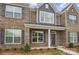 Charming brick townhome featuring gray shutters, craftsman columns, and professionally landscaped yard at 5527 Stafford Rd # 34, Charlotte, NC 28215