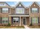 Charming brick townhome featuring gray shutters, craftsman columns, and professionally landscaped yard at 5527 Stafford Rd # 34, Charlotte, NC 28215