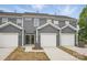 Front view of a modern row of townhomes with garages and concrete driveways at 5527 Stafford Rd # 34, Charlotte, NC 28215