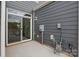 Outdoor patio features sliding glass door with gray siding and utility connections at 5527 Stafford Rd # 34, Charlotte, NC 28215