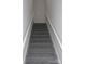 Carpeted stairs with a white handrail lead to the upper level of this beautiful home at 1647 Davis Farm Rd, York, SC 29745
