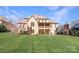 Sprawling green lawn behind a grand brick home featuring a covered patio and balcony at 1716 Funny Cide Dr, Waxhaw, NC 28173