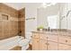 Bathroom with granite countertops, wooden cabinets, brown tiled shower with a built in shelf, and a toilet at 1716 Funny Cide Dr, Waxhaw, NC 28173