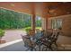 Inviting covered patio with brick columns, wood ceiling, fan, and an outdoor dining set at 1716 Funny Cide Dr, Waxhaw, NC 28173