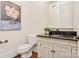 Charming powder room with a decorative mirror, elegant vanity, and floral artwork at 1716 Funny Cide Dr, Waxhaw, NC 28173