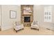 Sitting area with a stone fireplace and two armchairs at 1716 Funny Cide Dr, Waxhaw, NC 28173