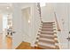 Carpeted stairway leading to upper level with wood railing and natural light at 1716 Funny Cide Dr, Waxhaw, NC 28173
