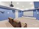Home theater room with blue walls, theater seating, projector, and a large screen at 1716 Funny Cide Dr, Waxhaw, NC 28173