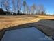 Open backyard with a concrete pad and mature trees at 174 Salem Springs Ln, Statesville, NC 28625