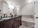 Modern bathroom featuring double vanity, granite counters, and a soaking tub at 204 Jonas Dr, Lincolnton, NC 28092