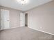 A neutral bedroom with access to another room and white doors at 204 Jonas Dr, Lincolnton, NC 28092