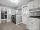 Well-equipped laundry room with modern washer and dryer, storage cabinets and view to the outside at 204 Jonas Dr, Lincolnton, NC 28092