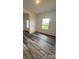 Well-lit living area showcasing modern flooring and a view through a large window, next to a doorway at 282 New Salem Rd, Statesville, NC 28625