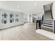 Open-concept living room with stairs, multiple windows, and light-colored hardwood floors at 6025 Countess Dr # 54, Charlotte, NC 28217