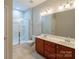 Bathroom featuring double sink vanity, tile flooring, and glass shower at 7108 Kinley Commons Ln, Charlotte, NC 28278